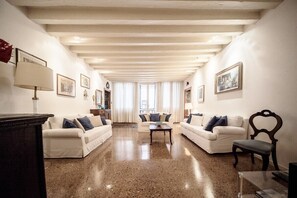 A spacious living room with two sofas, a coffee table, and a wooden chair.
