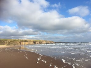 A beach with waves, cliffs, and a partly cloudy sky. - Fabulous open plan house in country estate - 4 bedrooms, each with its own bathroom (By Arbroath)