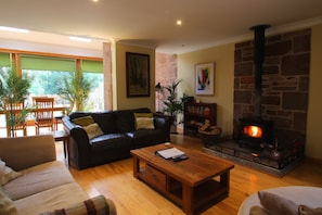 A cozy living room with a fireplace, a sofa, a coffee table, and a bookshelf. - Fabulous open plan house in country estate - 4 bedrooms, each with its own bathroom (By Arbroath)