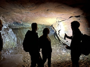 A cave with rocky walls and a stream.