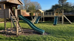 A playground with wooden structures, including slides and a climbing area.