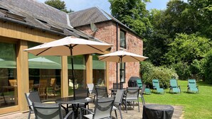 A patio area with outdoor furniture, including tables and chairs, and a covered seating area with umbrellas.