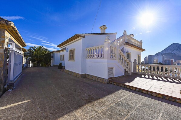 Un edificio blanco con un balcón y una escalera que conduce a una terraza.