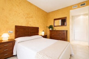 Une chambre à coucher avec une tête de lit en bois, une table de chevet avec une lampe, une commode et un miroir au mur.