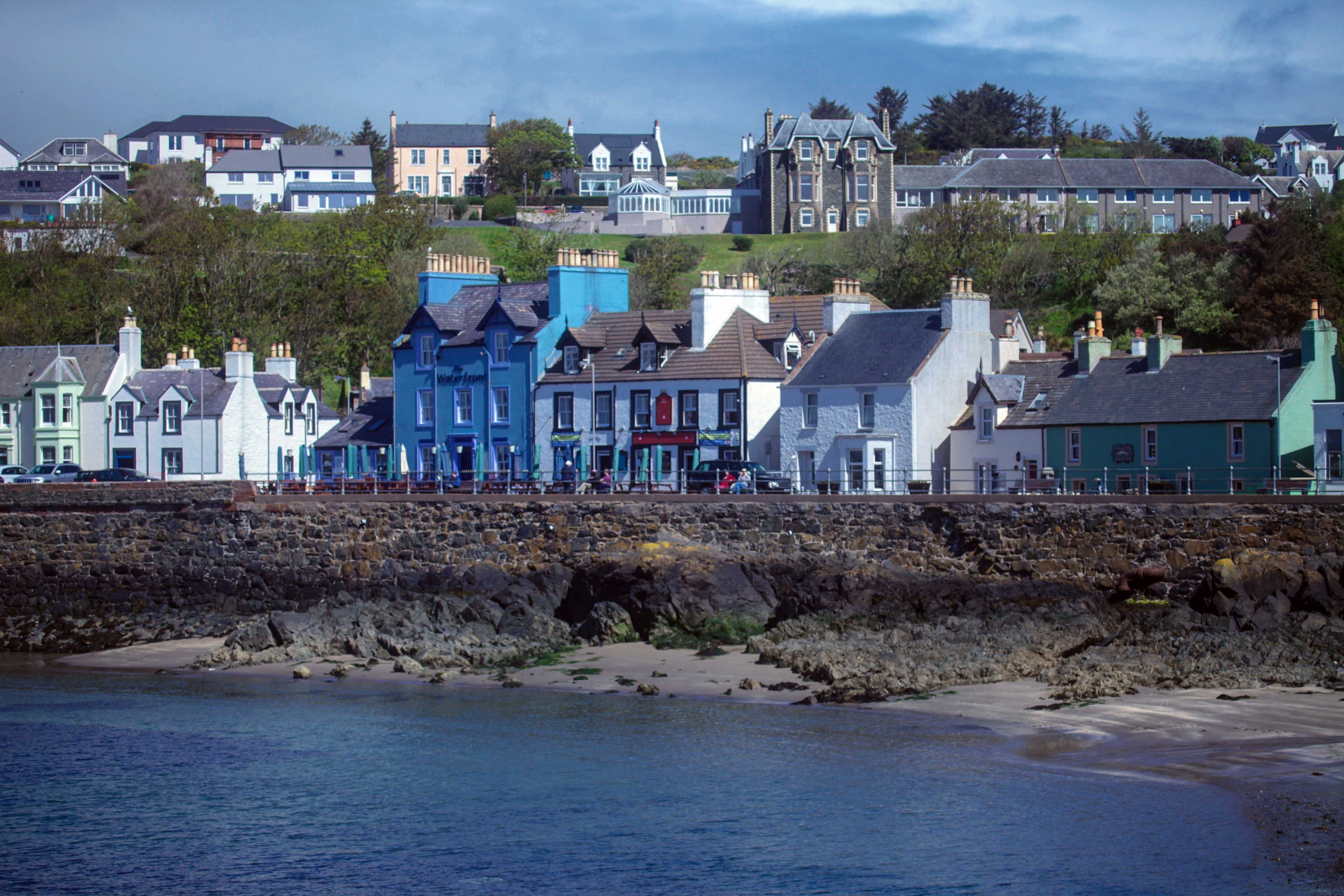 Une ville côtière aux bâtiments aux couleurs vives, qui bordent le front de mer.