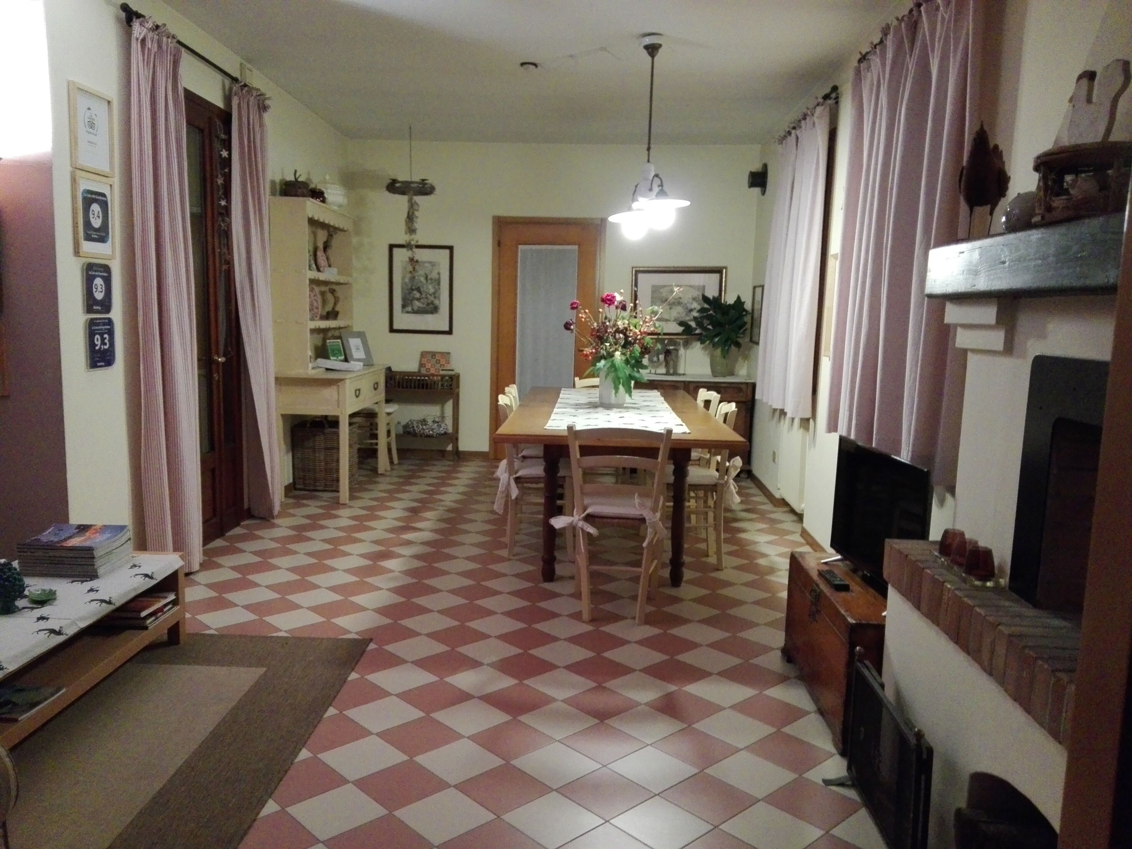 A dining area with a checkered floor, wooden furniture, and a chandelier.