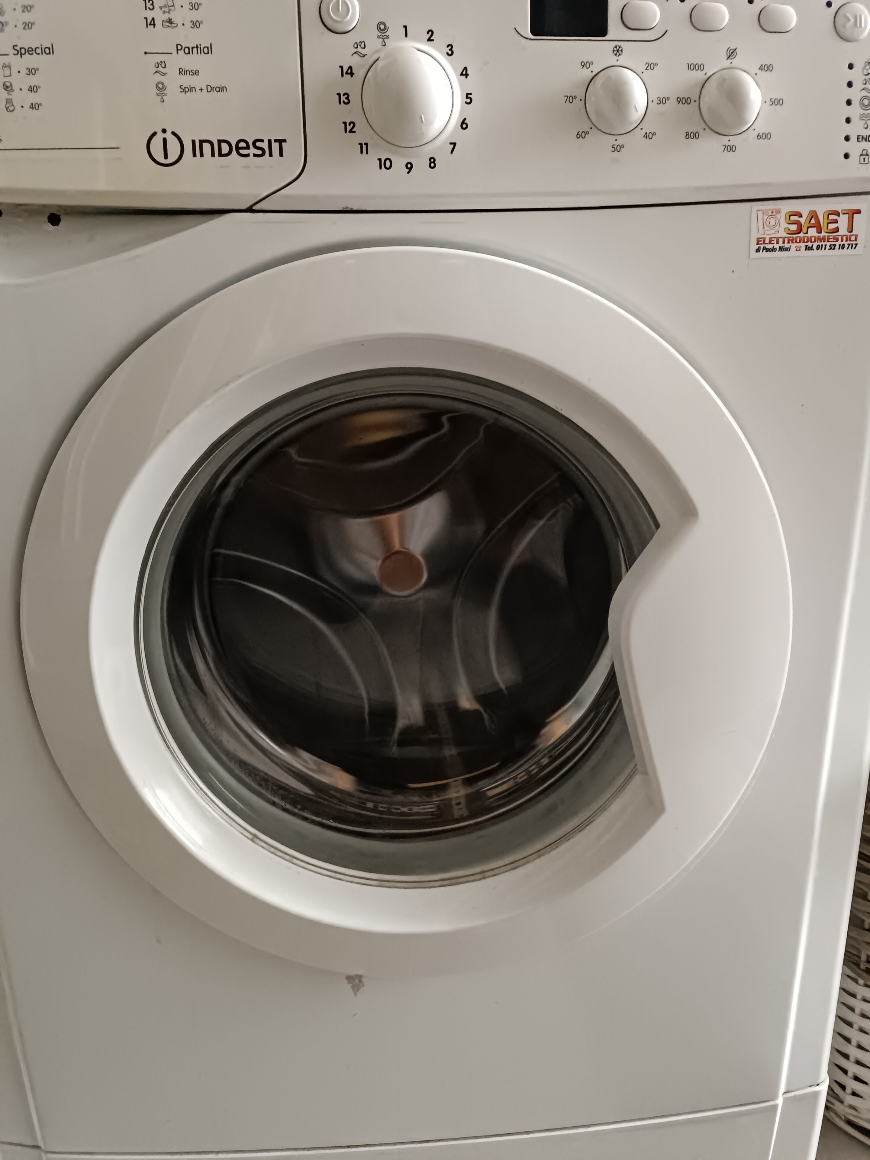 Een voorzichtszicht van een witte wasmachine met een bedieningspaneel erboven.