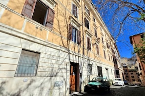 Un bâtiment doté d’une grande fenêtre, d’une porte et d’une voiture garée.