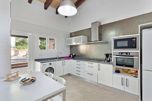 A modern kitchen with white cabinets, a built-in microwave, oven, and a sink.