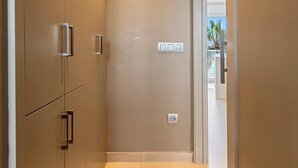 A hallway with beige walls, a door with a handle, and a light switch on the wall. - Apartment with terrace facing beach and near train (Torredembarra)