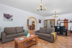 Una sala de estar con dos sofás, una mesa de centro de madera y un comedor con sillas y una mesa.
