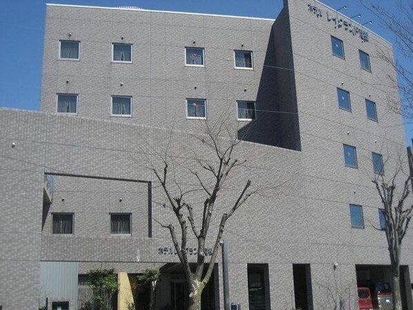 A multi-story building with a modern architectural design, featuring a prominent black triangular structure on the facade.