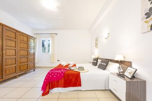 A bedroom with a bed, bedside table, and wardrobe.