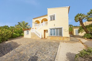 Un edificio de dos pisos con un patio empedrado de piedra, un balcón y un letrero que dice 'Casa Cardo'.
