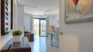 Une chambre d’hôtel avec un balcon, un coin repas et un espace de vie.