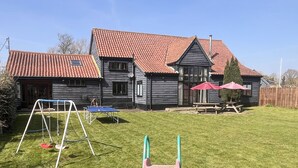 A house with a red-tiled roof, a wooden exterior, and a well-maintained lawn. - The Dairy Hall at Partridge Lodge (Woodbridge)