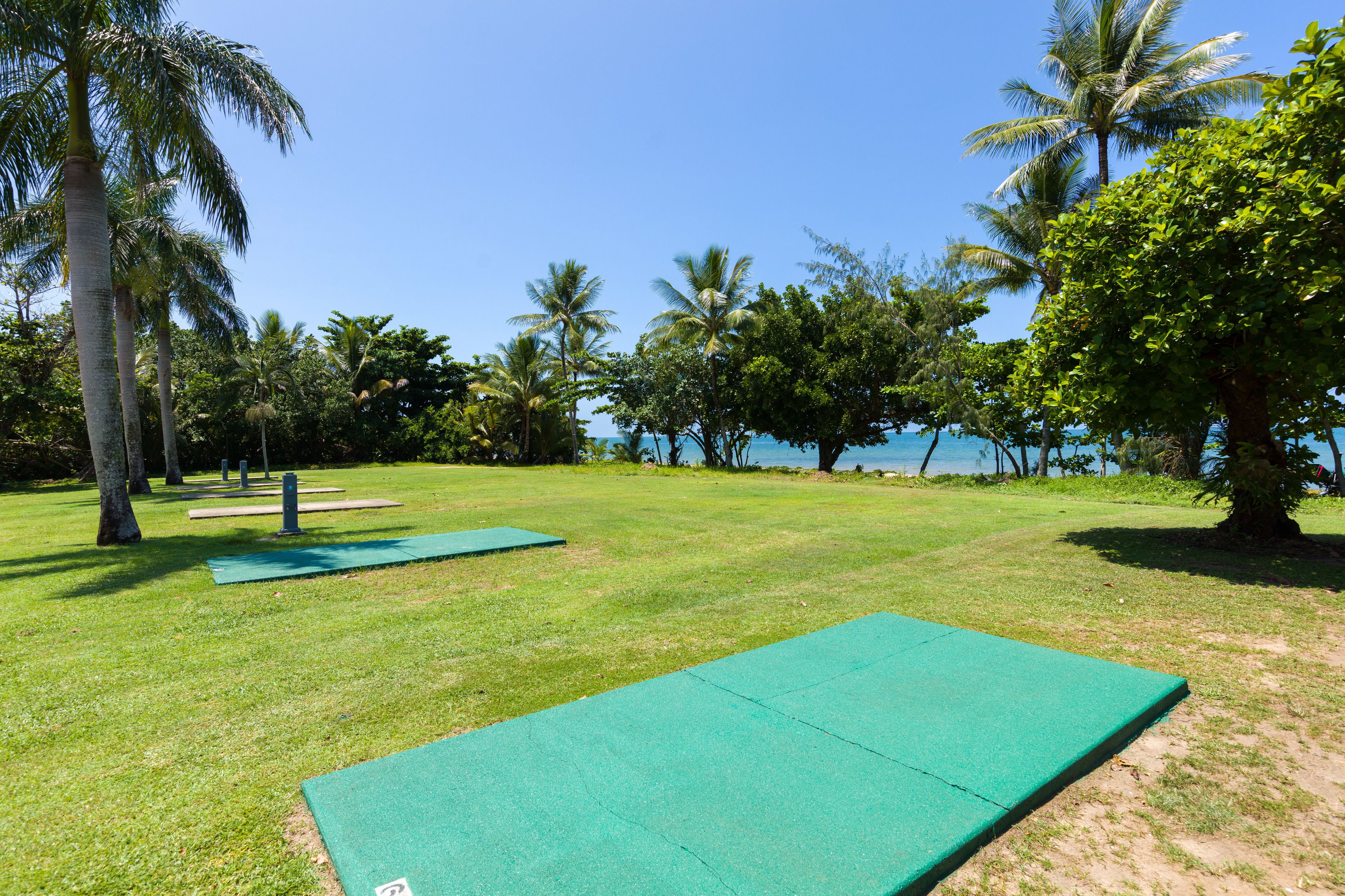 A grassy area with exercise mats and a clear view of the sea.