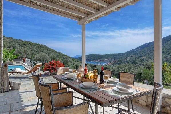 A dining area with a table set for four, overlooking a mountainous landscape.