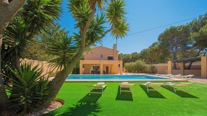 A modern house with a swimming pool, surrounded by artificial green grass and palm trees. - Villa Bernia - PlusHolidays (Moraira)
