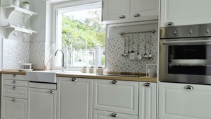 Eine moderne Küche mit weißen Schränken, einer Holz Arbeitsplatte und einem Edelstahlbackofen.