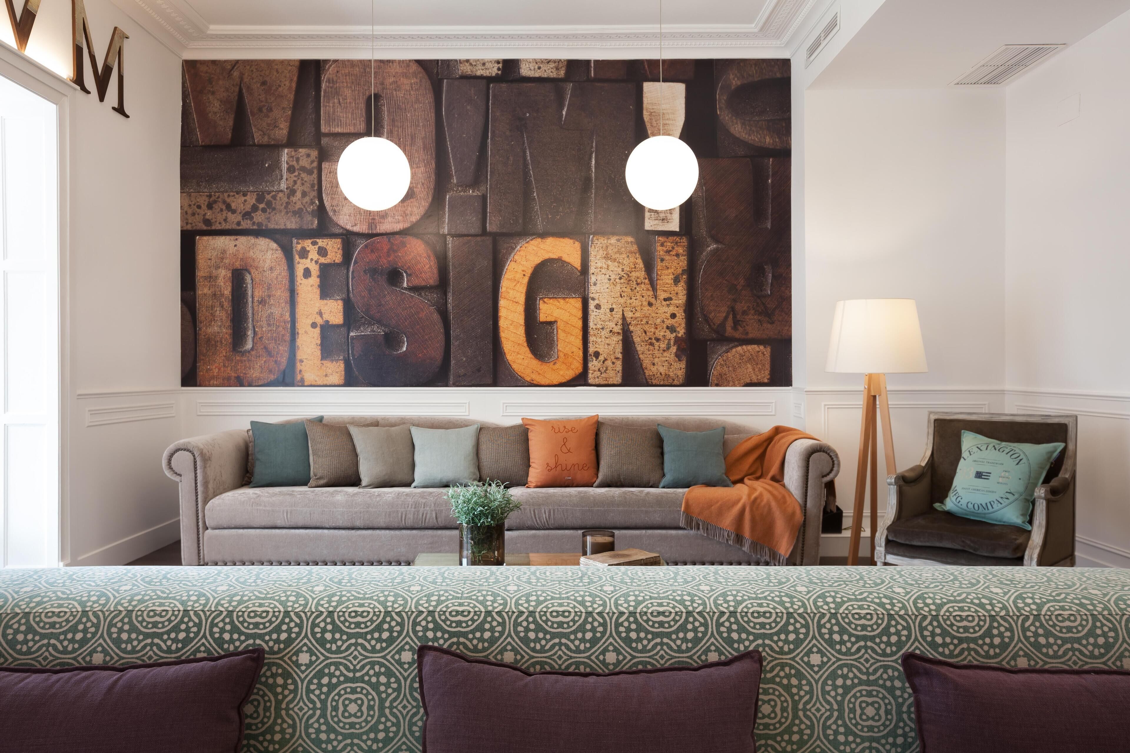 Ein Wohnzimmer mit großem Wandbild, einer Couch, einem Beistelltisch und einer Lampe.