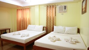 Une chambre d’hôtel avec deux lits, chacun étant recouvert de draps et de serviettes blancs.