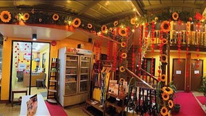 Un hall d’hôtel avec un tapis rouge, un comptoir d’accueil et un escalier.
