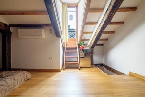 A loft bedroom with a wooden ladder leading to a balcony, a bed, and a potted plant. - Lion's 4 (Venice)