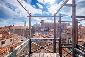 A high vantage point view of a cityscape with traditional architecture, including terracotta roofs and a dome structure.