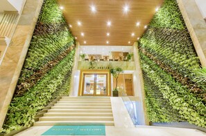 A staircase leading to a boutique hotel entrance with a green wall on either side. - Soho Boutique Hotel (Da Nang)