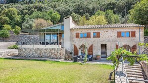 A two-story stone building with a modern glass extension, outdoor seating, and a vineyard. - Ca na Copea - Four Bedroom Villa, Sleeps 7 (Pollença)