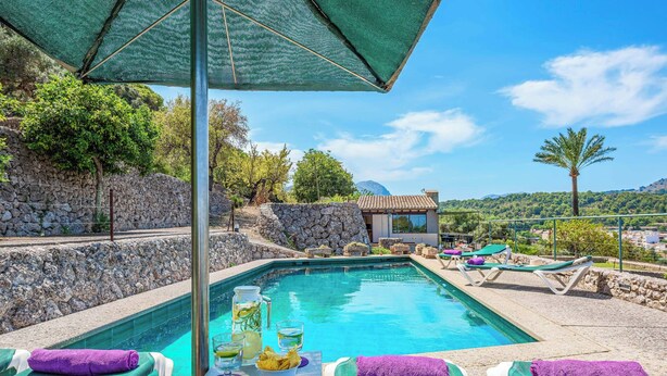 A pool area with lounge chairs, a table with drinks, and a view of the surrounding landscape. - Ca na Copea - Four Bedroom Villa, Sleeps 7 (Pollença)