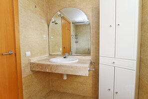 A bathroom with a sink, mirror, and cabinets. - MAR CAMBRILS Apartment (Cambrils)