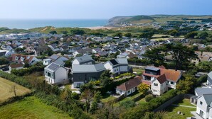 Ein Wohngebiet mit Häusern, einige mit Solaranlagen, und Blick auf das Meer im Hintergrund.