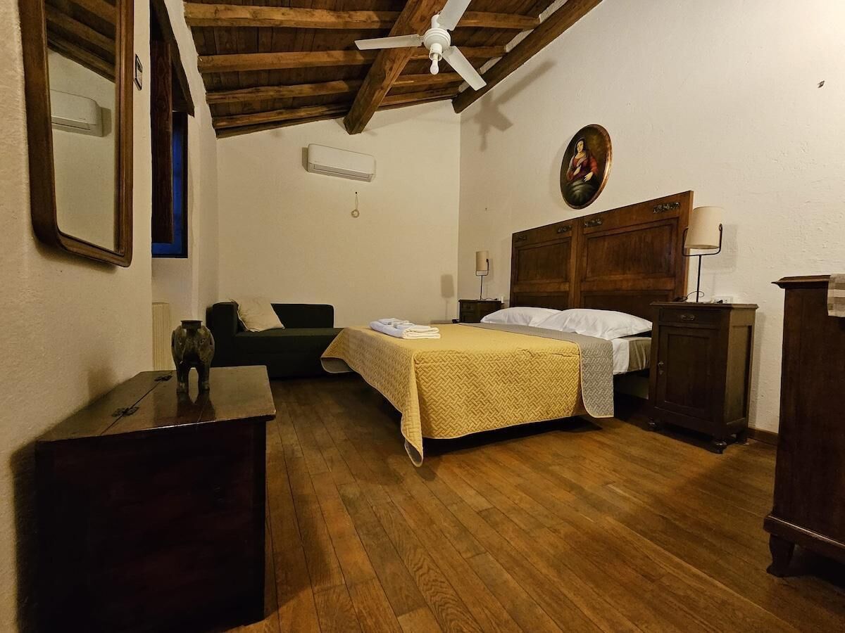 A room with a bed, a desk, a chair, a wooden cabinet, and a ceiling fan.