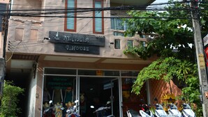 A multi-story building with a sign that reads "9 HOUSE". There are several motorcycles parked in front of the building. - Nirvana Guesthouse (Koh Tao)