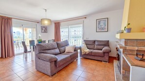A spacious living area with two sofas, a dining table, and a fireplace. - Villa Casita - PlusHolidays (Calpe)