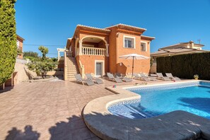 A two-story building with a swimming pool, sun loungers, and a covered patio area. - Villa Casita - PlusHolidays (Calpe)
