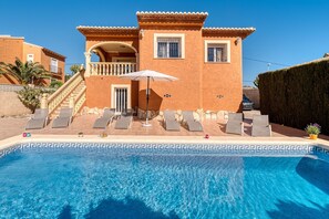 A two-story building with a swimming pool, outdoor seating, and a staircase leading to the upper level. - Villa Casita - PlusHolidays (Calpe)