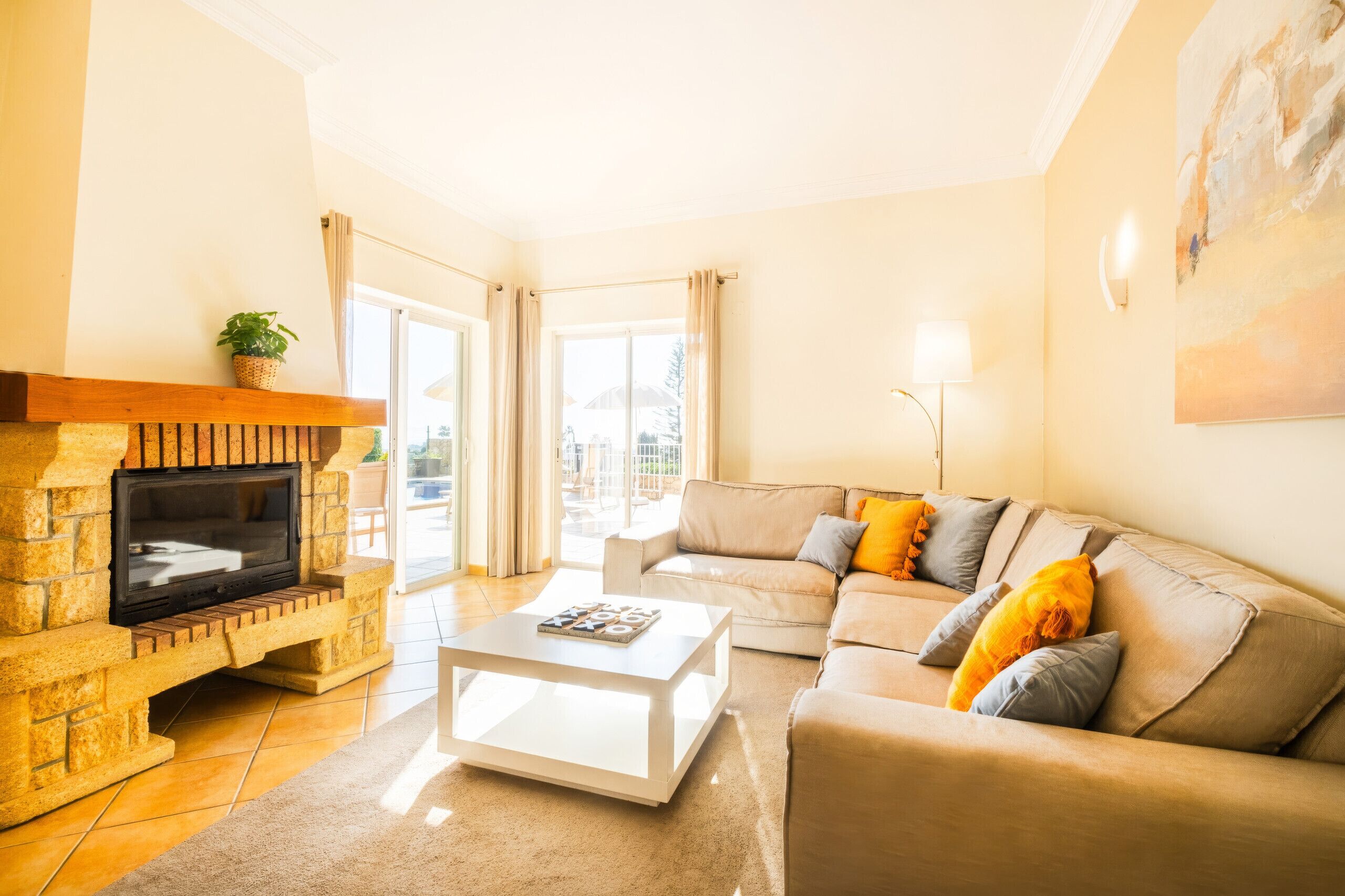 A living room with a fireplace, a sofa, a coffee table, and a painting on the wall.