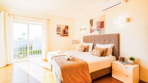 A hotel room with a large bed, two bedside tables, a window with a view, and a balcony. - Villa with Heatable Pool and BBQ in Albufeira (Albufeira)