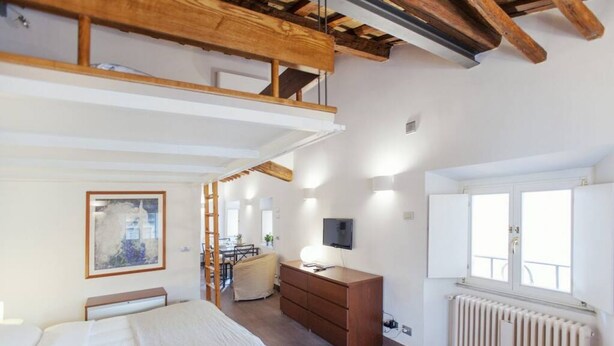 A bedroom with a bed, a dresser, a TV, a radiator, and a window. - Rome, Piazza Navona, characteristic apartment for 5 people (Rome)