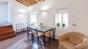 A dining area with a glass table, chairs, a sofa, wooden beams, and a staircase. - Rome, Piazza Navona, characteristic apartment for 5 people (Rome)