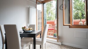 A dining area with a table, chairs, and a bowl of fruit.