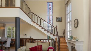 Ein großzügiger Wohnbereich mit Treppe, Kamin und Essbereich.