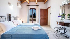 A bedroom with two beds, a wooden ceiling, a balcony with a view, and a desk with a mirror. - Villa Rachi - Four Bedroom Villa, Sleeps 8 (Rachi)