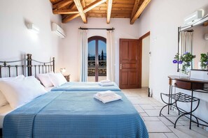 Une chambre avec deux lits, un plafond en bois, un balcon avec vue et un bureau avec un miroir.