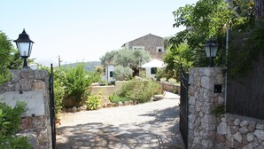 A stone gate leading to a house with a stone facade, surrounded by greenery and a clear sky. - Coster Catalanet, Villa On The Edge Off Pollença With Amazing Views ETV 1808 (Pollença)