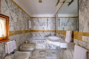 Kombination af bruser/badekar, hårtørrer, bidet, håndklæder
