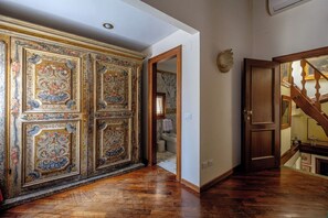 A hallway with ornate wall panels, a wooden door, and a staircase. - Casa Dell'Albero (Venice)